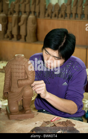 L'uomo la fabbricazione di un Guerriero di terracotta souvenir in una fabbrica, Xi'an, Shaanxi Province, Cina Foto Stock