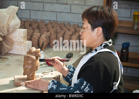 La donna la fabbricazione di un Guerriero di terracotta souvenir in una fabbrica, Xi'an, Shaanxi Province, Cina Foto Stock