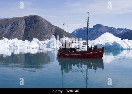 Barche da pesca sulla gita turistica nella parte anteriore di iceberg al fiordo di Qooroq, Narsarsuaq, Kitaa, Groenlandia Foto Stock