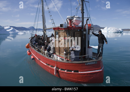 Barche da pesca sulla gita turistica nella parte anteriore di iceberg al fiordo di Qooroq, Narsarsuaq, Kitaa, Groenlandia Foto Stock