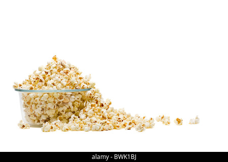 Deliziosi popcorn in recipiente di vetro su sfondo bianco Foto Stock