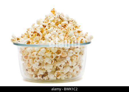 Deliziosi popcorn in recipiente di vetro su sfondo bianco Foto Stock