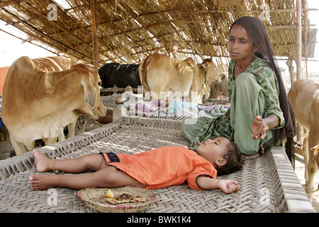 Donna e bambino in provvisoria di alloggi di emergenza per i rifugiati, Dadu, Pakistan Foto Stock