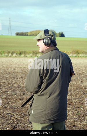 Un sparatutto (pistola) di attesa per la selvaggina di penna a salire su una ripresa in Cambridgeshire Regno Unito Foto Stock