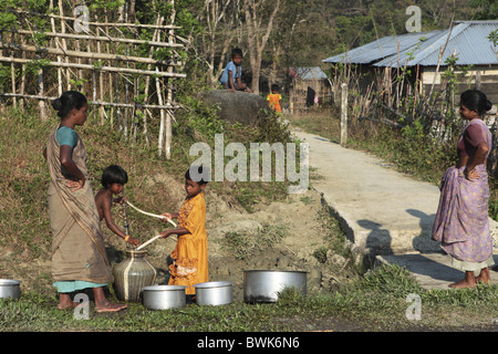 Le donne indiane ottenere acqua dal bene al mattino, Baratang, Middle Andaman, Andamane, India Foto Stock