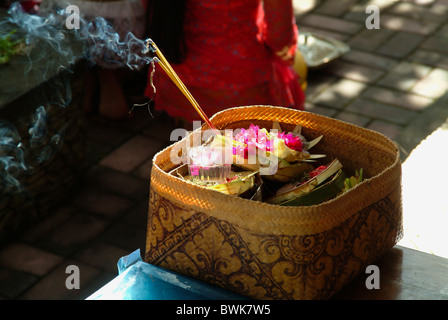 A un tempio cerimonia in Ubud, Bali, le offerte sono a sinistra per la divinità fatte di bit di cibo, denaro, fiori, bambù e incenso. Foto Stock