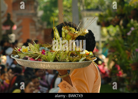 A un tempio cerimonia in Ubud, Bali, le offerte sono a sinistra per la divinità fatte di bit di cibo, denaro, fiori, bambù e incenso. Foto Stock