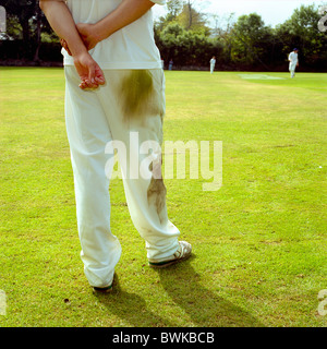 L'uomo fielding nella partita di cricket in bianco abbigliamento sportivo Foto Stock