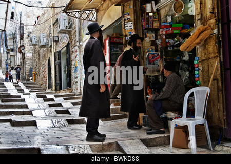 Gli ebrei ortodossi con un venditore araba, la città vecchia di Gerusalemme Foto Stock