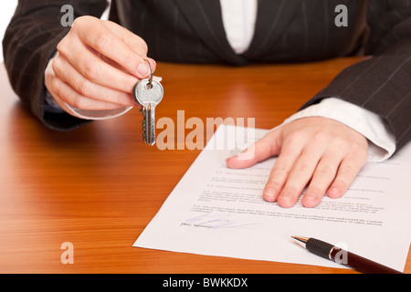Business donna detiene le chiavi e contratto in mani. Isolato su sfondo bianco. Foto Stock