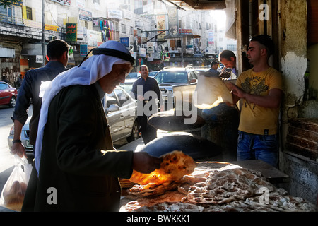Un palestinese in abbigliamento tradizionale, scegliendo la pita in una strada di Ramallah Foto Stock