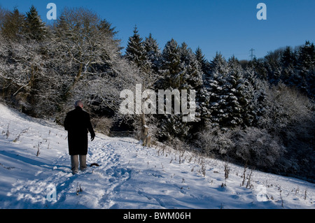 Uomo che cammina su una coperta di neve paesaggio Foto Stock
