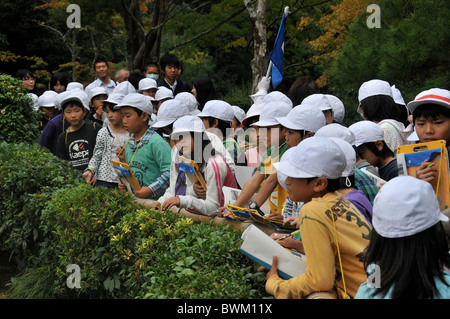 Scuola le ragazze e i ragazzi della scuola visitando il Tempio Dorato, Kyoto, Giappone Foto Stock