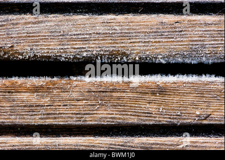 Close up di cristalli di ghiaccio formato su legno decking durante un gelo Foto Stock