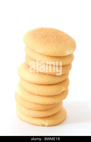 Vista ravvicinata di alcuni biscotti di spugna in una pila su sfondo bianco Foto Stock