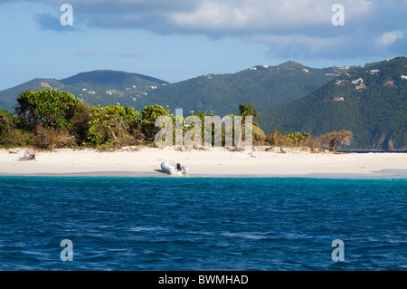 Isolotto di Sandy Spit, Isole Vergini Britanniche, con Tortola in background. L'isola ha una spiaggia di sabbia bianca immacolata Foto Stock