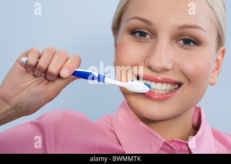 Immagine di felice femmina spazzolino da denti tenendo a portata di mano prima di effettuare la pulizia dei denti Foto Stock