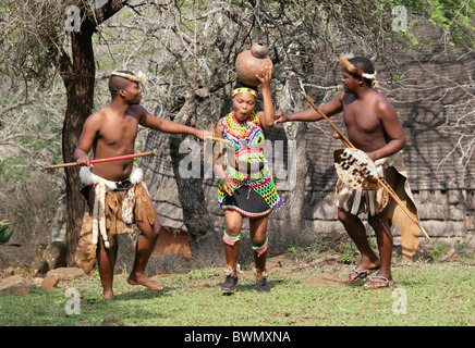 Giovani Guerrieri Zulu flirtare con una fanciulla Zulu Shakaland, villaggio Zulu, Valle Nkwalini, Kwazulu Natal, Sud Africa. Foto Stock