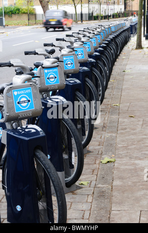 Un taxi nero cabina passando una fila di 'Boris delle bici a noleggio a Borgo a sud di Londra Foto Stock