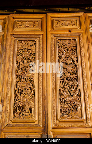 Porte di legno intagliato su un edificio di Dayan città vecchia di Lijiang, nella provincia dello Yunnan in Cina Foto Stock