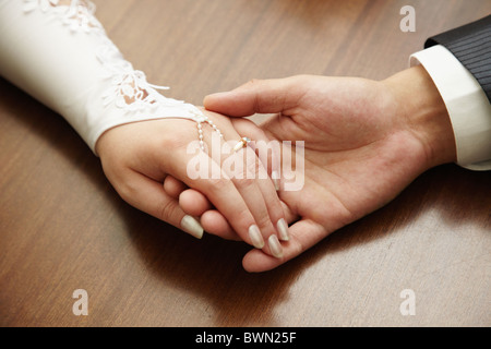 Le mani di una coppia appena sposata da vicino Foto Stock