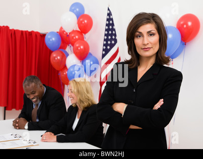 Stati Uniti d'America, Illinois, Metamora, ritratto di donna al posto di polling, noi bandiera, palloncini e vota in background Foto Stock