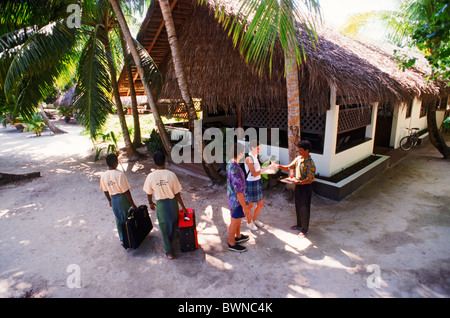 Due turisti di essere accolti a Fihalhohi island con bevande tropicali alle Maldive Foto Stock