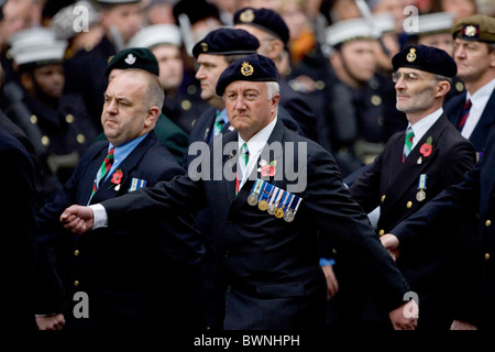 I veterani con le medaglie e di papavero marzo passato presso il cenotafio in Whitehall sul ricordo domenica per commemorare le vittime della guerra Foto Stock