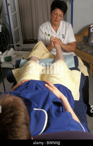 Ostetrica in gravidanza con trattamento di riflessologia plantare Foto Stock