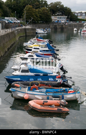 Barche dai colori vivaci ormeggiate di fila al porto di Saundersfoot nel Galles del Sud. Foto Stock