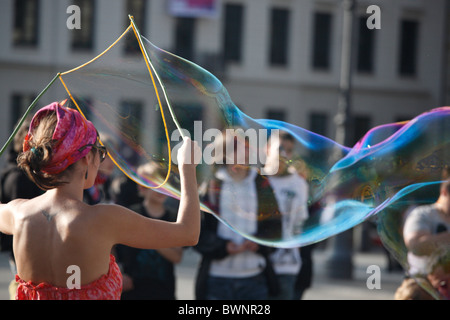 Donna creando un gigante di bolle di sapone Foto Stock