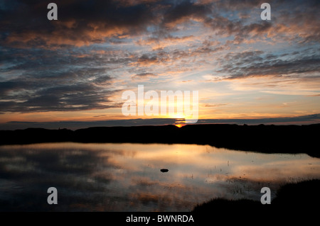 Riflessi del tramonto e nuvole in acqua di stagno su Dartmoor Devon UK Foto Stock