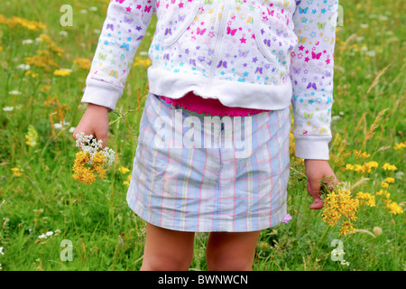 Ragazza con fiori in mano verde prato primavera Foto Stock