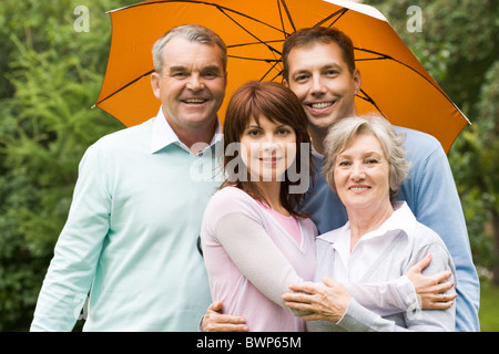 Ritratto di senior e coppie giovani sotto ombrellone esterni Foto Stock