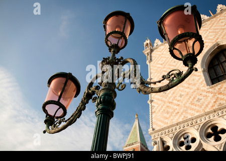 Un lampione di fronte al Palazzo del Doge di Venezia con la cima del campanile di San Marco chiesa appena visibile. Foto Stock