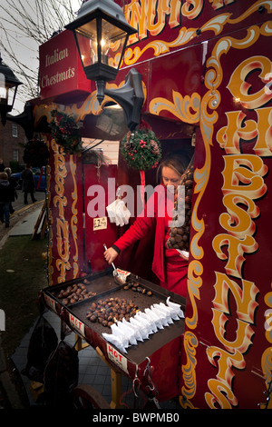 Hot castagne arrosto del venditore nel mercato di natale Foto Stock