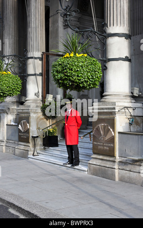 Il portiere attende pazientemente i clienti che arrivano al di fuori del Mandarin Oriental Hyde Park Hotel in Knightsbridge, Londra. Foto Stock