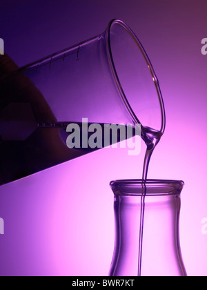 Bicchiere di vetro nel laboratorio di versamento di sostanze chimiche liquide in bicchieri Foto Stock