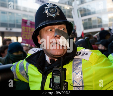 Un poliziotto ferito che è stato colpito da un missile generata durante una sommossa a Millbank, il Tory HQ al termine di una protesta. Foto Stock