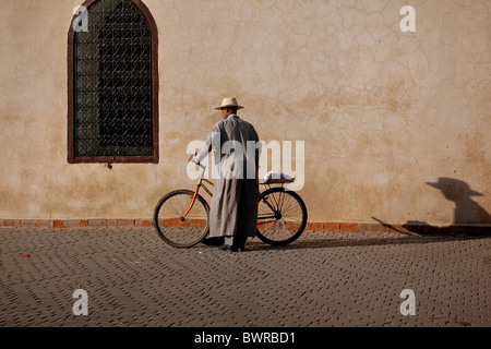 Uomo in bicicletta lasciando le Ali ben Youssef Mosque a Marrakech Foto Stock