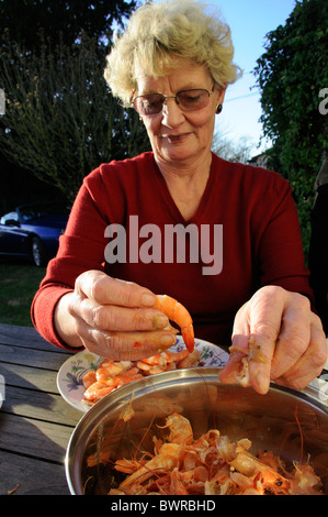 Donna stacca i gamberi in giardino Foto Stock