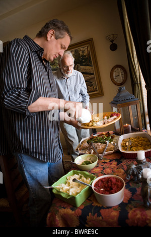 Famiglia vacanze godendo di pasto, self-serve a buffet a casa, Turchia, purè di patate e salsa di mirtilli, due generazioni, Stati Uniti Foto Stock