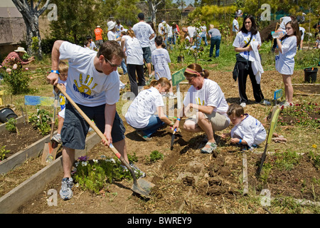 Gli studenti, i genitori e gli insegnanti lavorano sul giardino alla 24th Street School Garden sul grande domenica. West Adams, Los Angeles Foto Stock