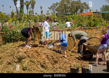 Gli studenti, i genitori e gli insegnanti lavorano sul giardino alla 24th Street School Garden sul grande domenica. West Adams, Los Angeles Foto Stock