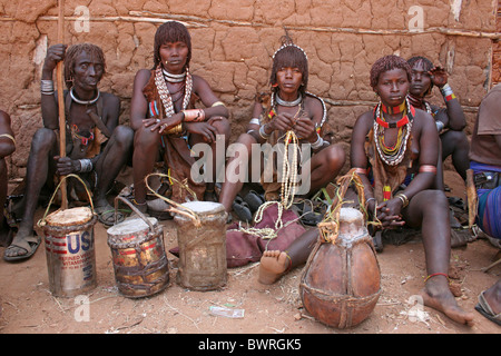 Gruppo di Hamer tribù donne vendita di miele in lattine di metallo, Turmi, Valle dell'Omo, Etiopia Foto Stock