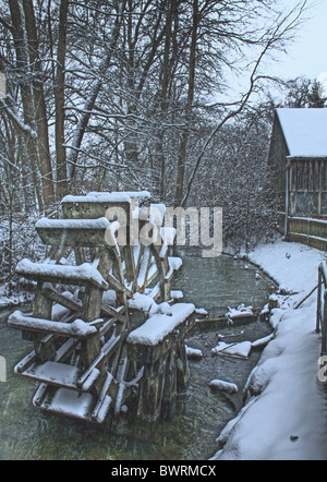 Neve invernale su una ruota del mulino sul fiume, sfondo romantico rurale stagionale Foto Stock