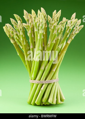 Un covone di asparagi su uno sfondo verde. Foto Stock