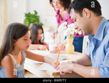 I genitori aiutano i bambini con i compiti Foto Stock