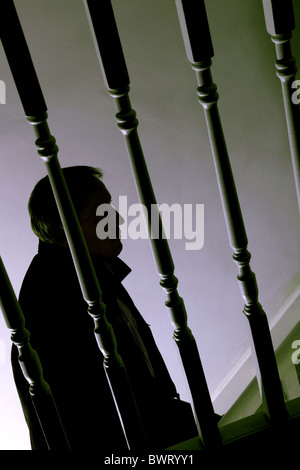 Silhouette di un uomo a camminare su una scala scura Foto Stock