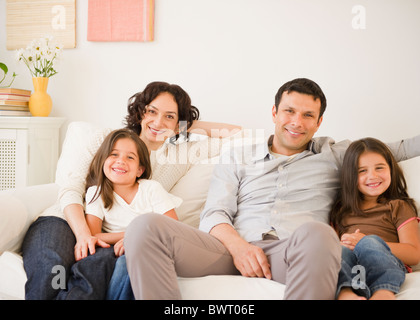 La famiglia felice seduto sul divano insieme Foto Stock